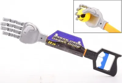 A toy robot hand with a handle and a small inset image of the hand holding a smiley face ball.