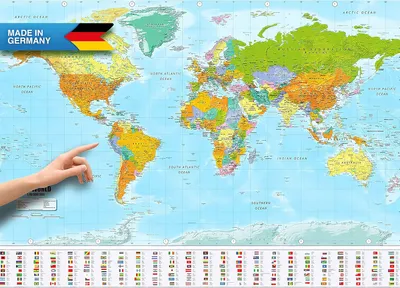 A hand is pointing to South America on a world map poster. The poster displays countries in different colors and has flags at the bottom. A "MADE IN GERMANY" banner with the German flag is in the top left corner.