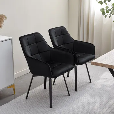 Two black dining chairs are shown in a room with a white cabinet and a wooden table.