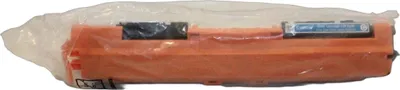 A toner cartridge is shown in its plastic packaging.
