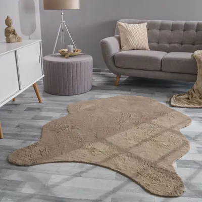 A living room scene with a sofa, ottoman, and a rug.