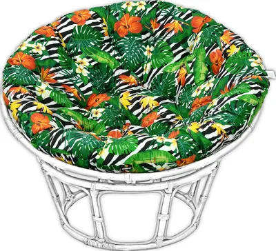 A round cushion with a tropical leaf and zebra print pattern sits on a white rattan chair.