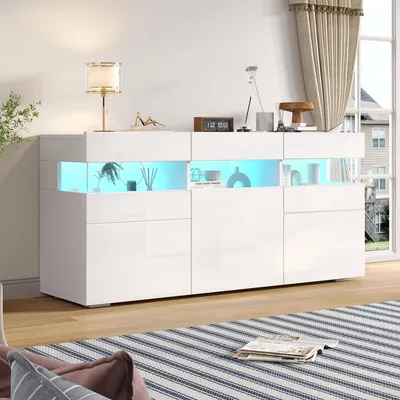 A modern white sideboard with LED lighting is displayed in a living room setting, with a striped rug in the foreground and curtains in the background.