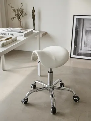 Nahaufnahme der weißen Kunstlederoberfläche des Praxishockers, bei der die feinen, präzisen Steppnähte der ergonomischen Sattelform im hellen Tageslicht gut sichtbar sind._#sku_SAFSPM1.974#