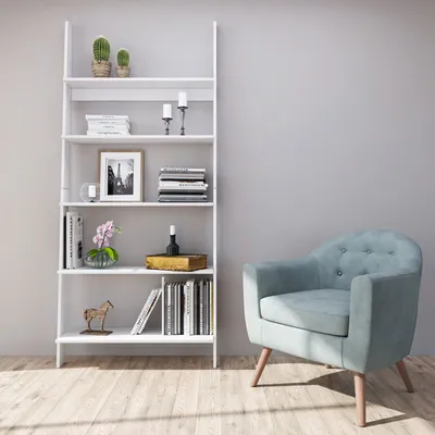A light-colored armchair sits next to a white ladder bookshelf filled with books and decorative items.