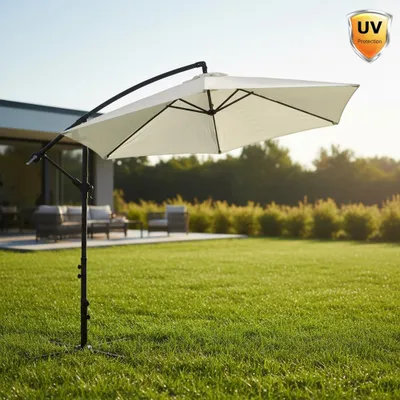 A cantilever umbrella is set up on a green lawn in front of a modern house with outdoor furniture.