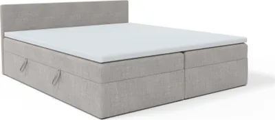 A grey upholstered bed with a white mattress topper and storage drawers is shown against a white background.