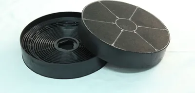 Two black charcoal filters for a range hood are shown on a light-colored surface.