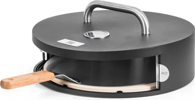 A black pizza oven with a silver handle and a wooden pizza peel.