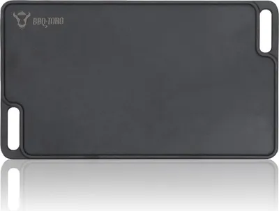 A black cast iron grill plate with handles, shown from a top-down perspective with a reflection below.