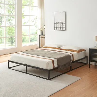A bedroom scene with a bed, nightstand, and large windows.