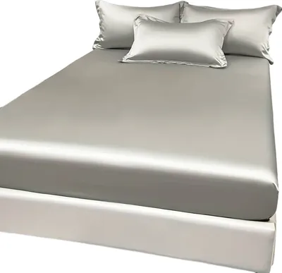 A bed with grey satin sheets and pillows.