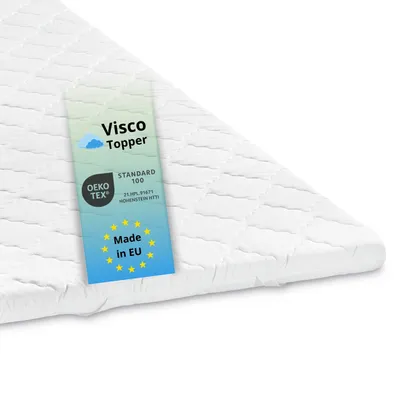 A close-up view of a white quilted mattress topper with a label attached.