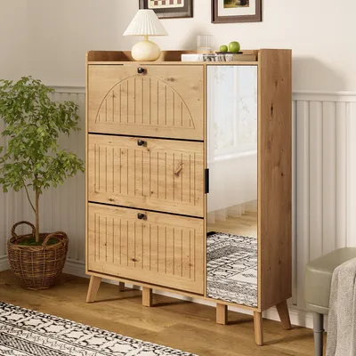 A wooden shoe cabinet with a mirror and storage shelves, placed in a room with a plant and a rug.
