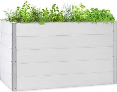 A white WPC raised garden bed filled with various green plants.