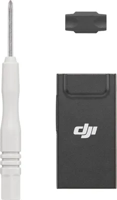 A screwdriver, a small adapter, and a black DJI dongle are arranged on a white background.