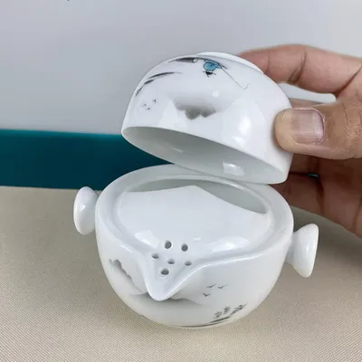 Immagine prodotto di Set da tè da viaggio in porcellana bianca smaltata, decorato con pittura a inchiostro. Include una teiera da 120 ml e una tazza da 110 ml