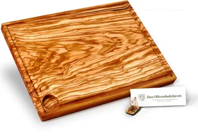 A wooden cutting board with a juice groove and a small tag with text and a logo.