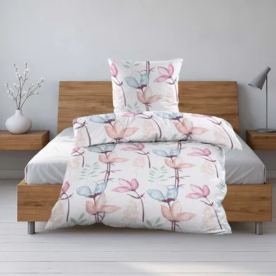 A neatly made bed with a floral patterned duvet and pillow.