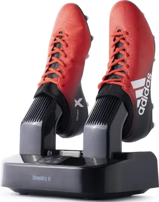 A shoe dryer with two red Adidas soccer cleats inserted.