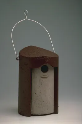 A birdhouse hanging from a wire.