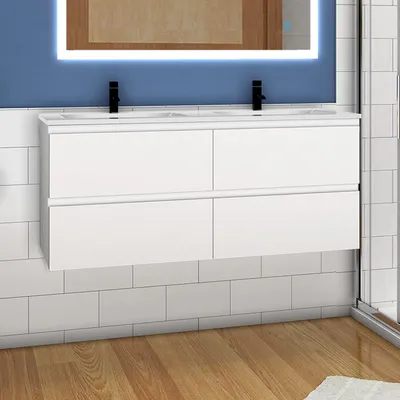 A modern bathroom vanity with a white countertop and four drawers, featuring black faucets and a backlit mirror above. The vanity is mounted on a blue tiled wall, with white subway tiles below and a wooden floor.