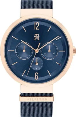 A close-up, front-facing view of a Tommy Hilfiger watch with a blue dial and rose gold accents.