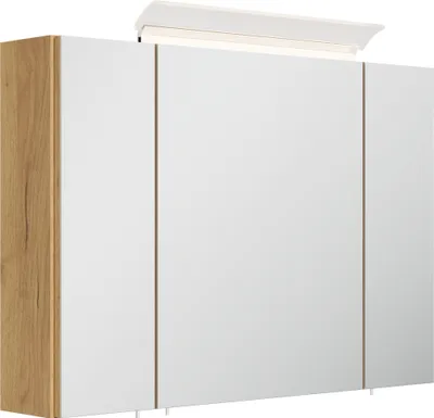 A modern bathroom cabinet with a wooden side and white doors, illuminated by an overhead light.