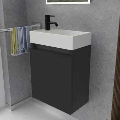 A modern bathroom vanity with a sink and faucet, with towels hanging on a rack.