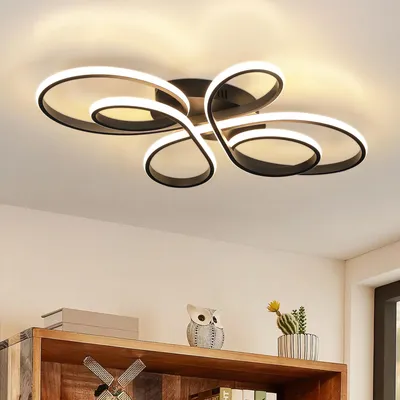 A modern ceiling light fixture with a swirling design, mounted on a white ceiling.