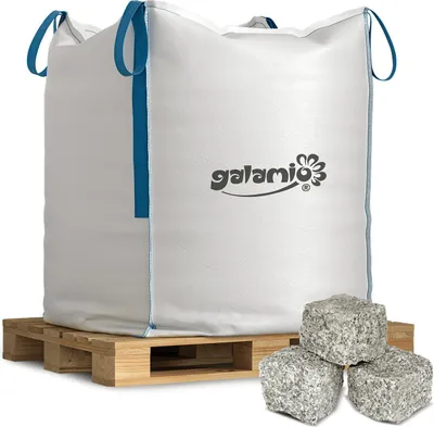 A large white BigBag filled with material, sitting on a wooden pallet, with three granite paving stones in the foreground.