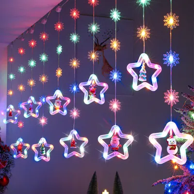 Christmas lights with snowflake and star shapes, some with festive figures inside, hanging indoors.