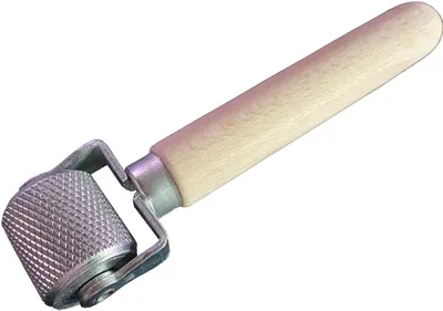 A tool with a wooden handle and a textured metal roller.