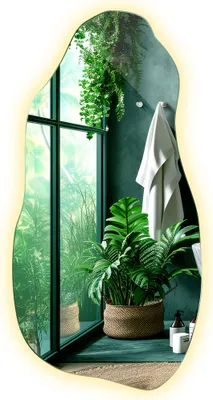 A bathroom scene with a large, irregularly shaped mirror reflecting lush greenery and a towel hanging on the wall.