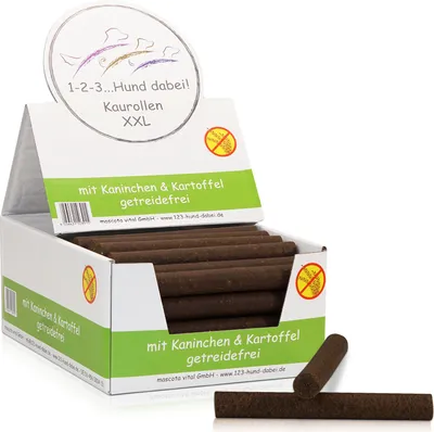 A display box filled with dog chew rolls, with some rolls spilling out and two lying in front.