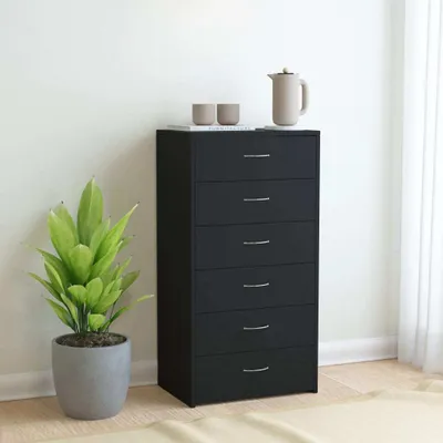 A black chest of drawers with six drawers, a potted plant, and two cups and a teapot on top, set against a white wall.
