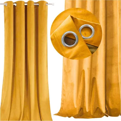A close-up view of a mustard yellow velvet curtain with grommets.