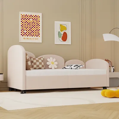 A child's bed with decorative pillows in a room with artwork on the wall.