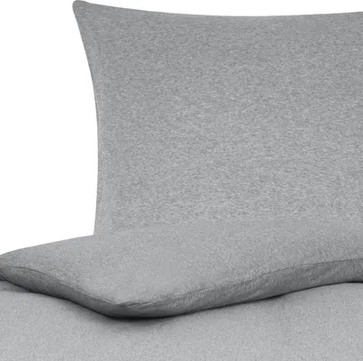 A close-up view of a grey pillow and bedsheet.