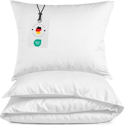 Three white pillows are stacked on top of each other against a white background. A tag is attached to the top pillow.