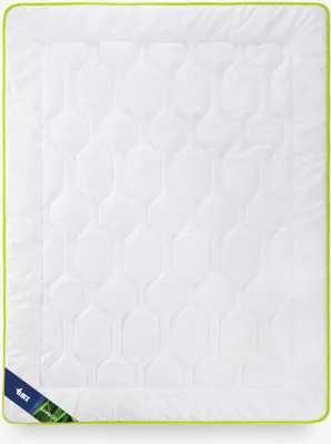 A white blanket with a geometric pattern and a green trim, lying flat on a white background. A small blue and green tag is visible in the bottom left corner.