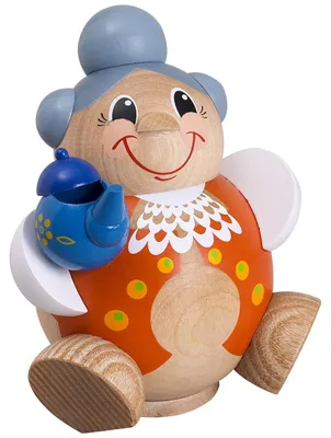 Eine fröhliche Holzfigur in Kugelform stellt eine lächelnde Oma mit grauem Dutt dar die eine blaue Teekanne in der Hand hält und ein orangefarbenes Kleid mit weißen und gelben Details trägt