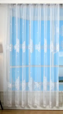A white lace curtain with a floral pattern is shown hanging in front of a window.