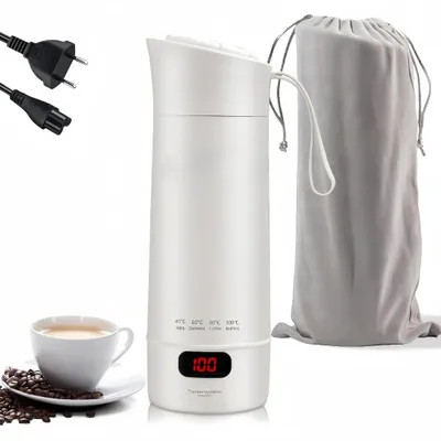 A white electric kettle with a digital display, along with power cords, a carrying pouch, and a cup of coffee with coffee beans.