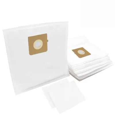 A close-up view of vacuum cleaner bags, with one bag prominently in the foreground and a stack of similar bags behind it. Two small squares of paper are also in the foreground.