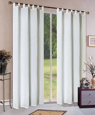 A window with white curtains and a view of greenery outside.
