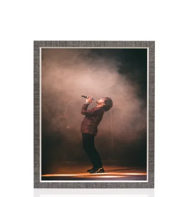 A framed picture of a singer performing on stage with smoke effects.