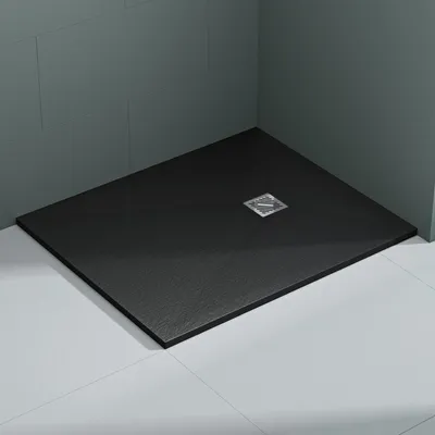 A black shower tray with a silver drain in a bathroom setting.