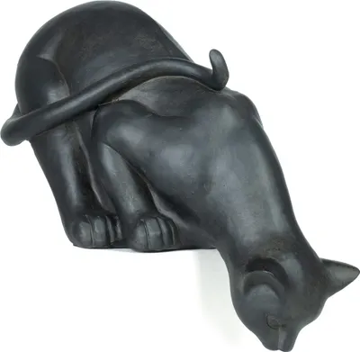 A dark gray sculpture of a cat is shown from a side angle, with its head lowered as if sniffing something.