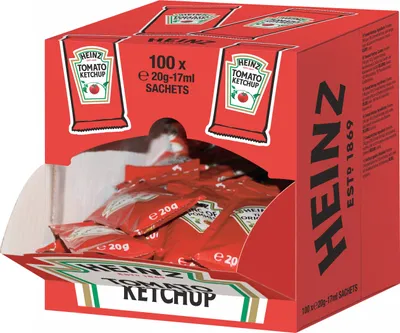 A display box filled with individual sachets of Heinz Tomato Ketchup.